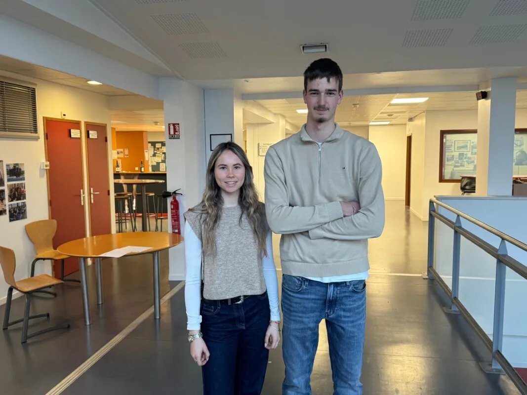 Une jeune fille et un jeune homme dans le hall d'un lycée