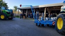 Des tracteurs, du métériel agricole et des personnes dans une cour de ferme