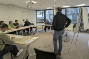 Des personnes et un animateur dans une salle.