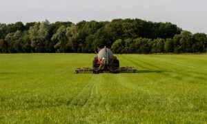 Un tracteur en train d'épandre du lisier dans un champ de culture