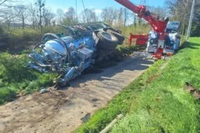 Une grue en train de dégager une tonne à lisier couchée lors d'un accident