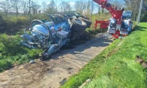 Une grue en train de dégager une tonne à lisier couchée lors d'un accident