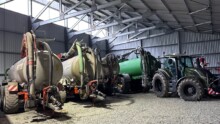 Des tonnes à lisier et un tracteurs dans un hangar à matériel agricole