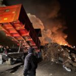 Une remorque en train de décharger des matériaux lors dun' manifestation agricole alors que le ciel est rempli de fumée