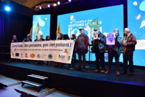 Des hommes et femmes portent une banderole sur un podium