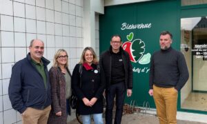 Trois hommes et deux femmesdevant une devanture