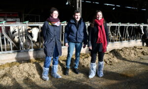 Un homme et deux femmes debout devant des cornadis