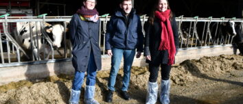 Un homme et deux femmes debout devant des cornadis