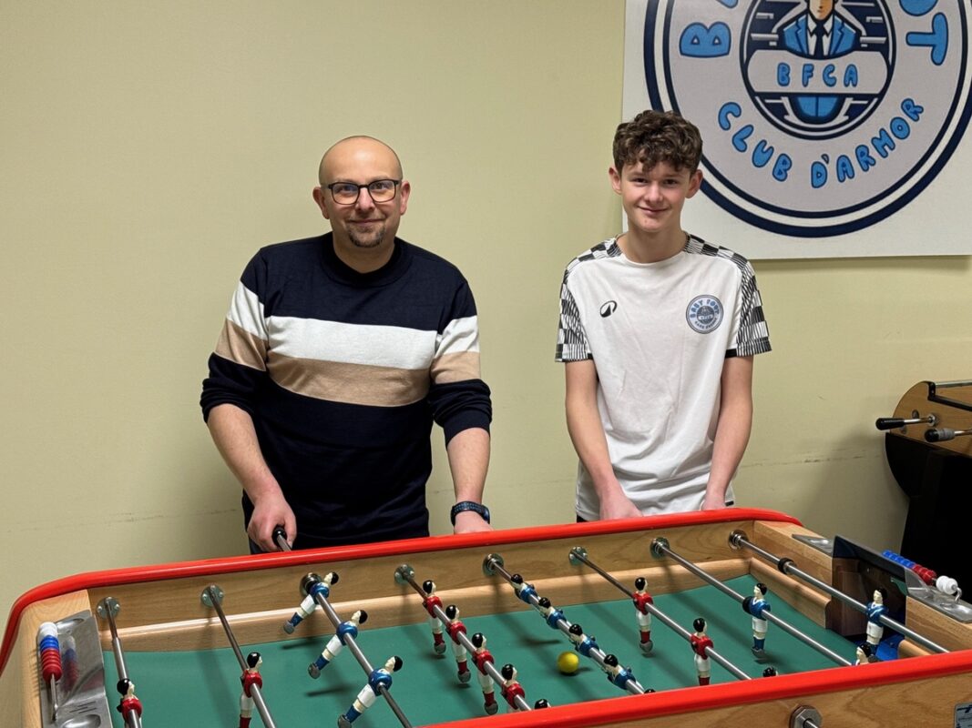 Un homme et son fils autour d'un baby-foot