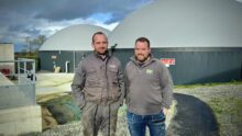 deux agriculteurs devant une unité de méthanisation