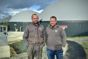 deux agriculteurs devant une unité de méthanisation