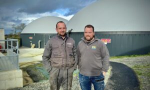 deux agriculteurs devant une unité de méthanisation
