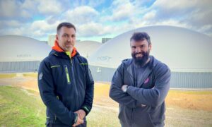 Deux agriculteurs devant un site de méthanisation