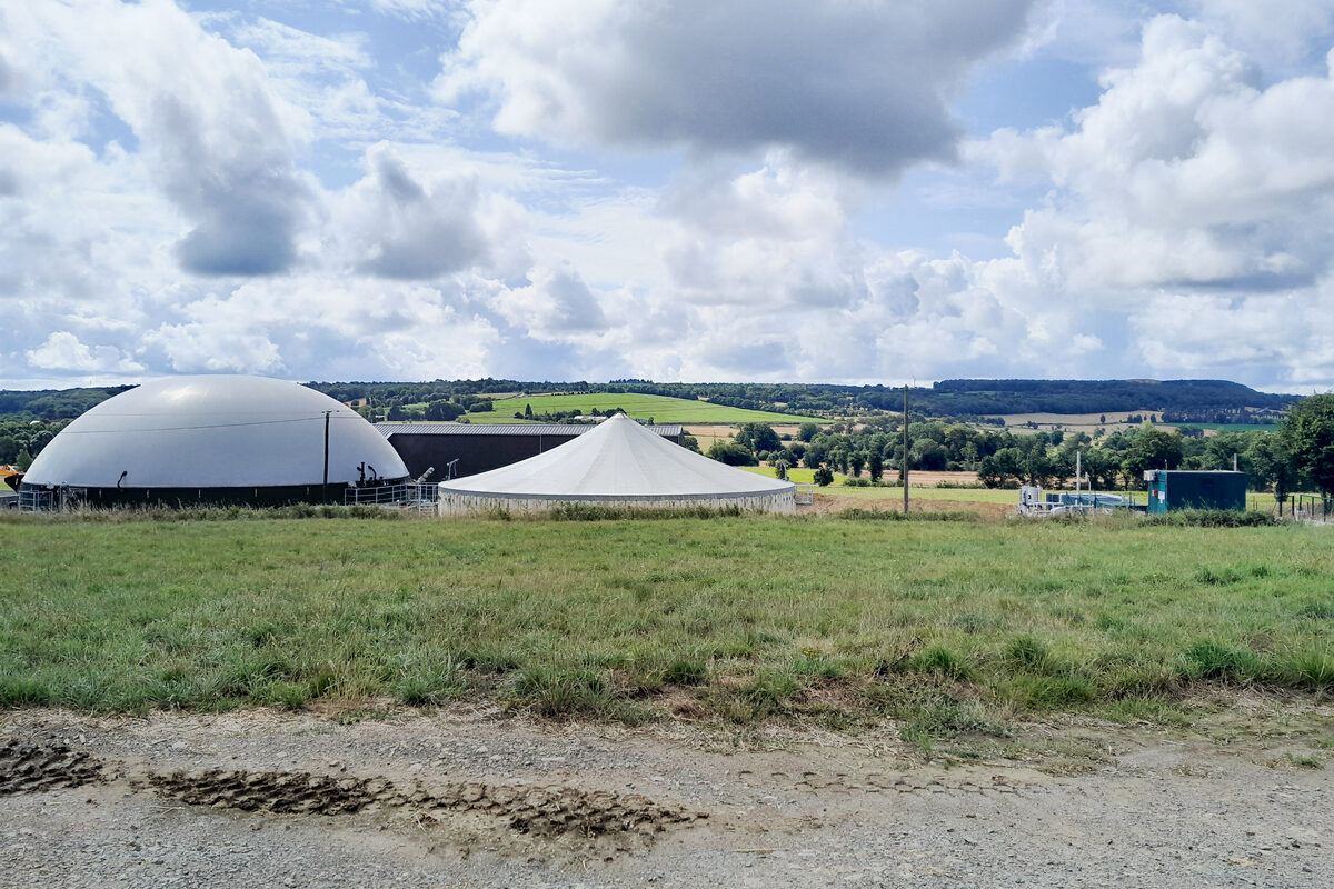 Une unité de méthanisation dans un paysan ge de campagne avec un ciel bleu et des nuages - Illustration Arrêter ou continuer de faire fonctionner son moteur ?