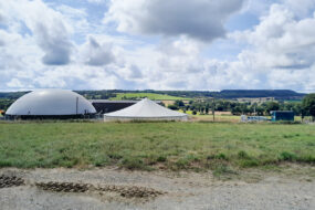 Une unité de méthanisation dans un paysan ge de campagne avec un ciel bleu et des nuages