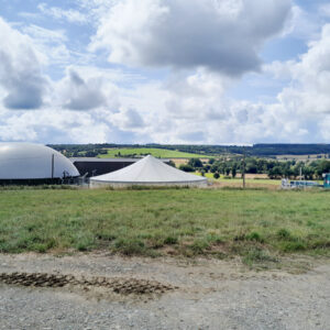 Une unité de méthanisation dans un paysan ge de campagne avec un ciel bleu et des nuages