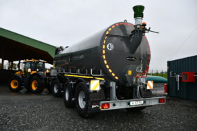 tracteur avec une remorque-citerne dans une cour de ferme