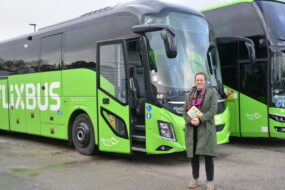 Une femme devant un bus vert
