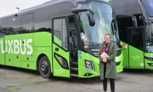 Une femme devant un bus vert