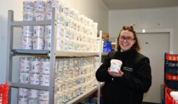 femme tenant du skyr devant une étagère