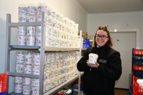 femme tenant du skyr devant une étagère