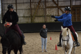 Deux jeunes cavaliers à cheval pratiquant le Horse Ball sous les yeux d'une monitrice.