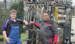 Deux hommes devant une cage de parage pour bovins