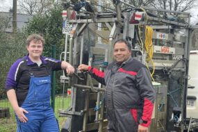 Deux hommes devant une cage de parage pour bovins