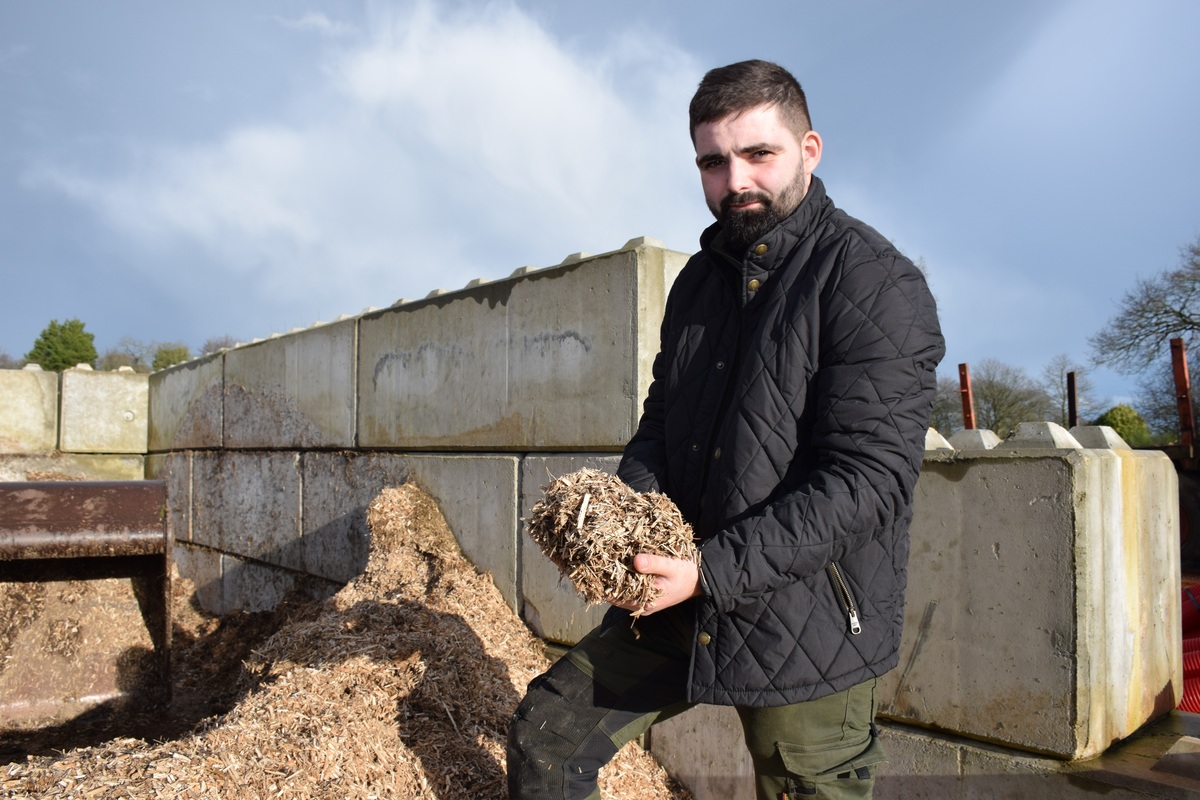 Un homme devant un silo de rhizomes de miscanthus « régénéré ».avec une poignée de ces rhizomes dans les mains - Illustration Les plus du miscanthus