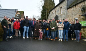 Des personnes devant des maisons de ferme
