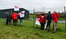 Des jeunes agriculteurs avec des drapeaux devant la station d'épuration