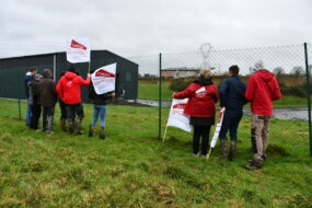 Des jeunes agriculteurs avec des drapeaux devant la station d'épuration