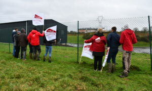 Des jeunes agriculteurs avec des drapeaux devant la station d'épuration