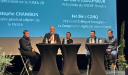 Des personnes à une tribune avec un écran géant derrière