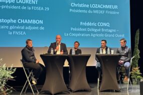 Des personnes à une tribune avec un écran géant derrière