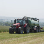 Un tracteur tirant une tonne à lisier lors d'un épandage sur prairie