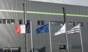 Quatre drapeaux sur des mâts : français, européen, blanc et breton
