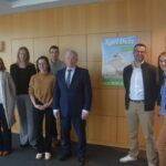 Des personnes dans une salle devant une affiche