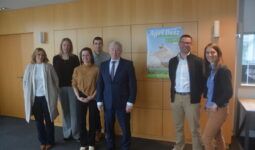 Des personnes dans une salle devant une affiche