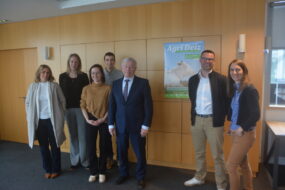 Des personnes dans une salle devant une affiche
