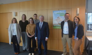 Des personnes dans une salle devant une affiche