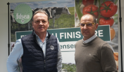 Deux hommes posent devant une affiche
