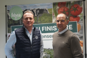 Deux hommes posent devant une affiche