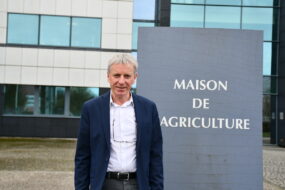 un homme devant des bâtiments de la maison de l'agriculture