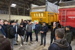 Des personnes devant des remorques agricoles