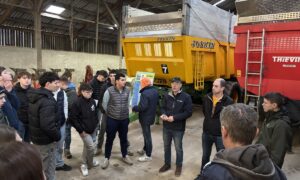 Des personnes devant des remorques agricoles