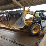 Un chariot télescopique avec un grappin dans un bâtiment