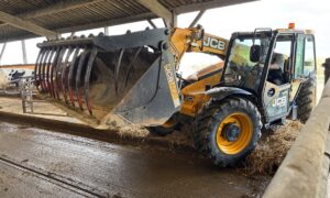 Un chariot télescopique avec un grappin dans un bâtiment