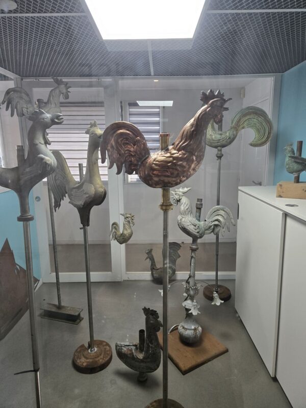 Des girouettes en forme de coqs stockés dans une pièce