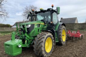 Un tracteur au travail avec une masse à l'avant et une charrue attelée
